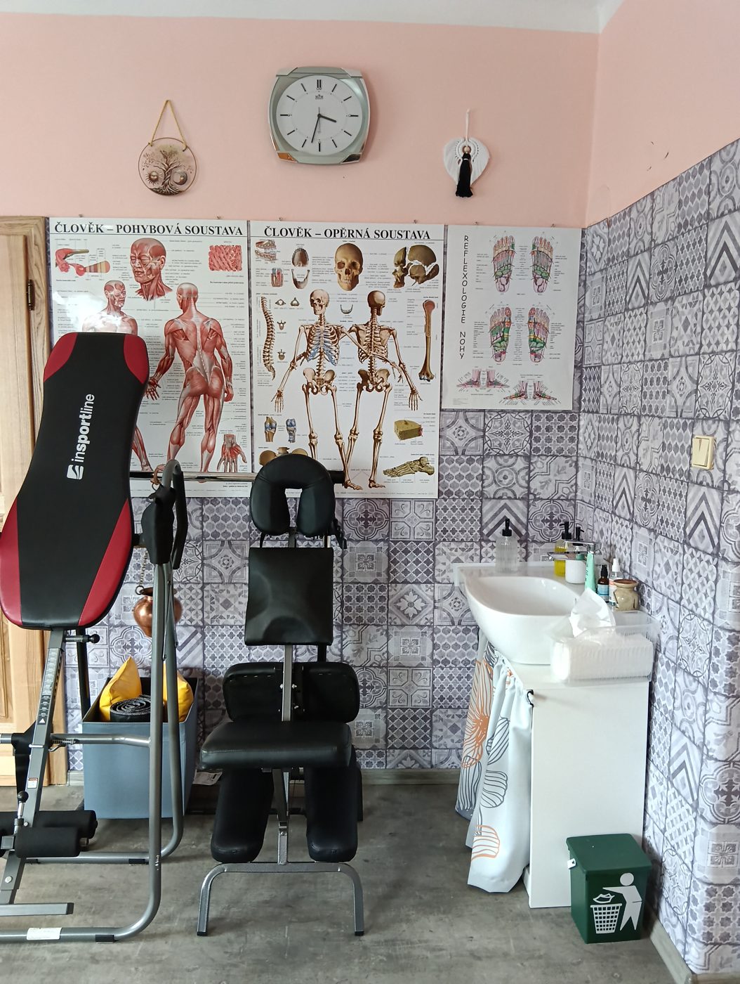 Masážní židle, inverzní lavice a anatomické plakáty ve studiu